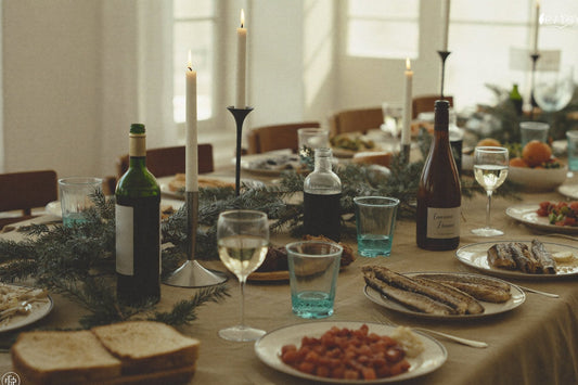 Julebord med lys, vin og dækkede tallerkener