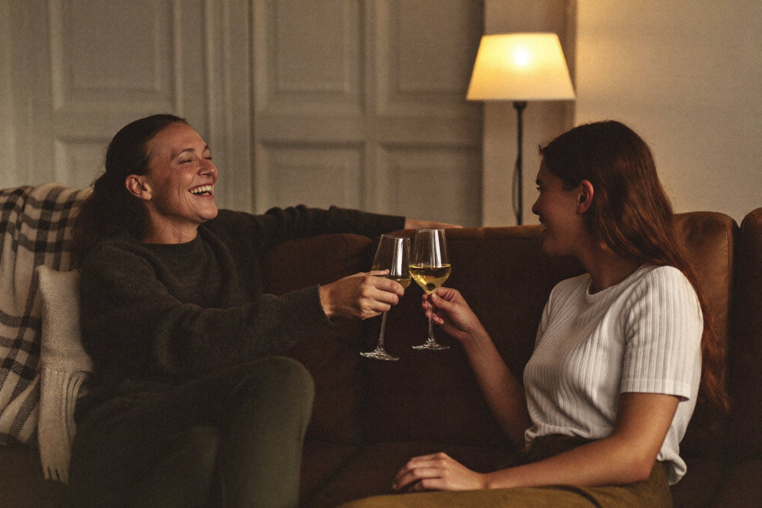 To kvinder skåler med hvidvin i en sofa